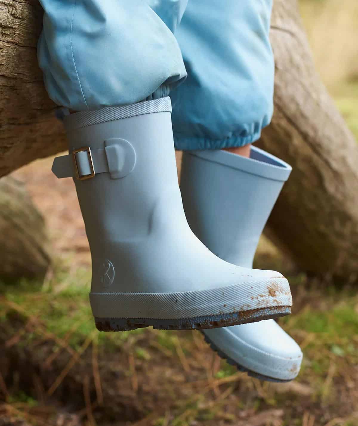 Child wearing blue natural rubber rain boots.