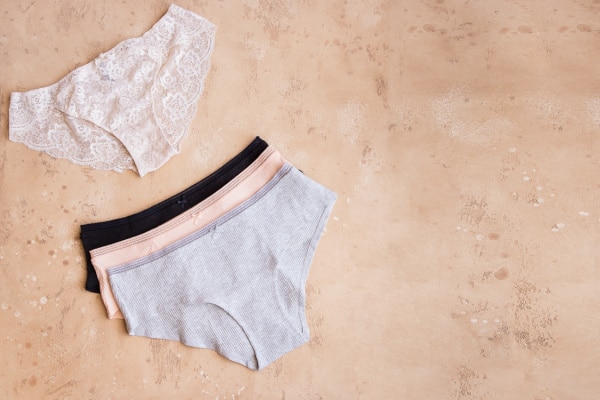 Four pairs of women's knickers on a beige background.