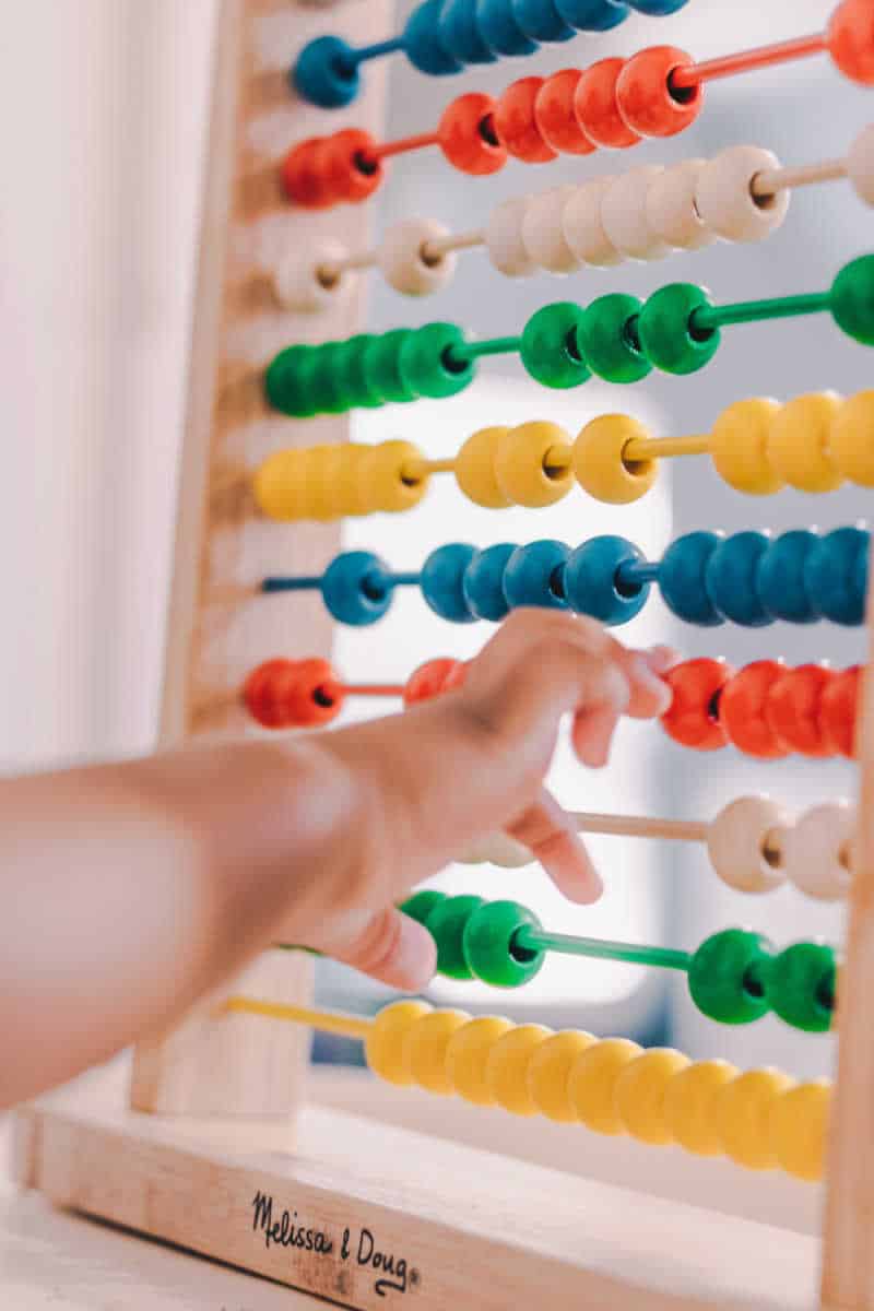 Baby playing with secondhand wooden toy.