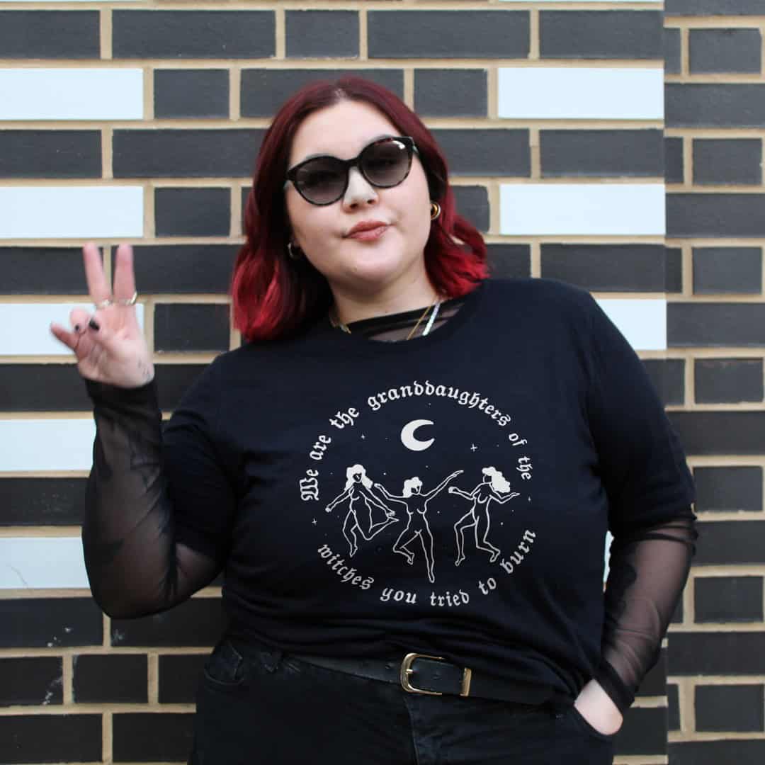 Person wearing a black feminist t-shirt from sustainable plus size slow fashion brand The Spark Company