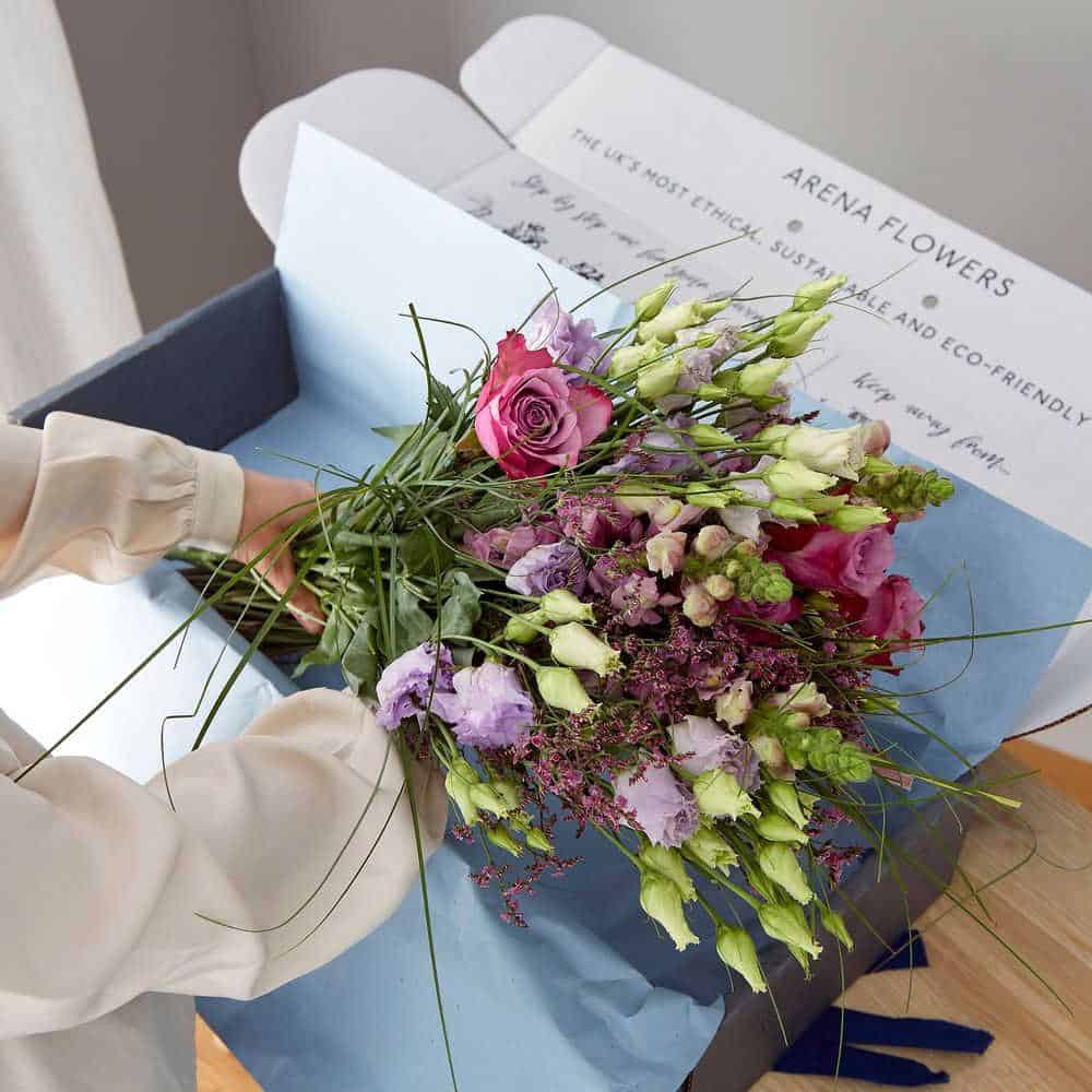 Person holding a bunch of flowers from Arena