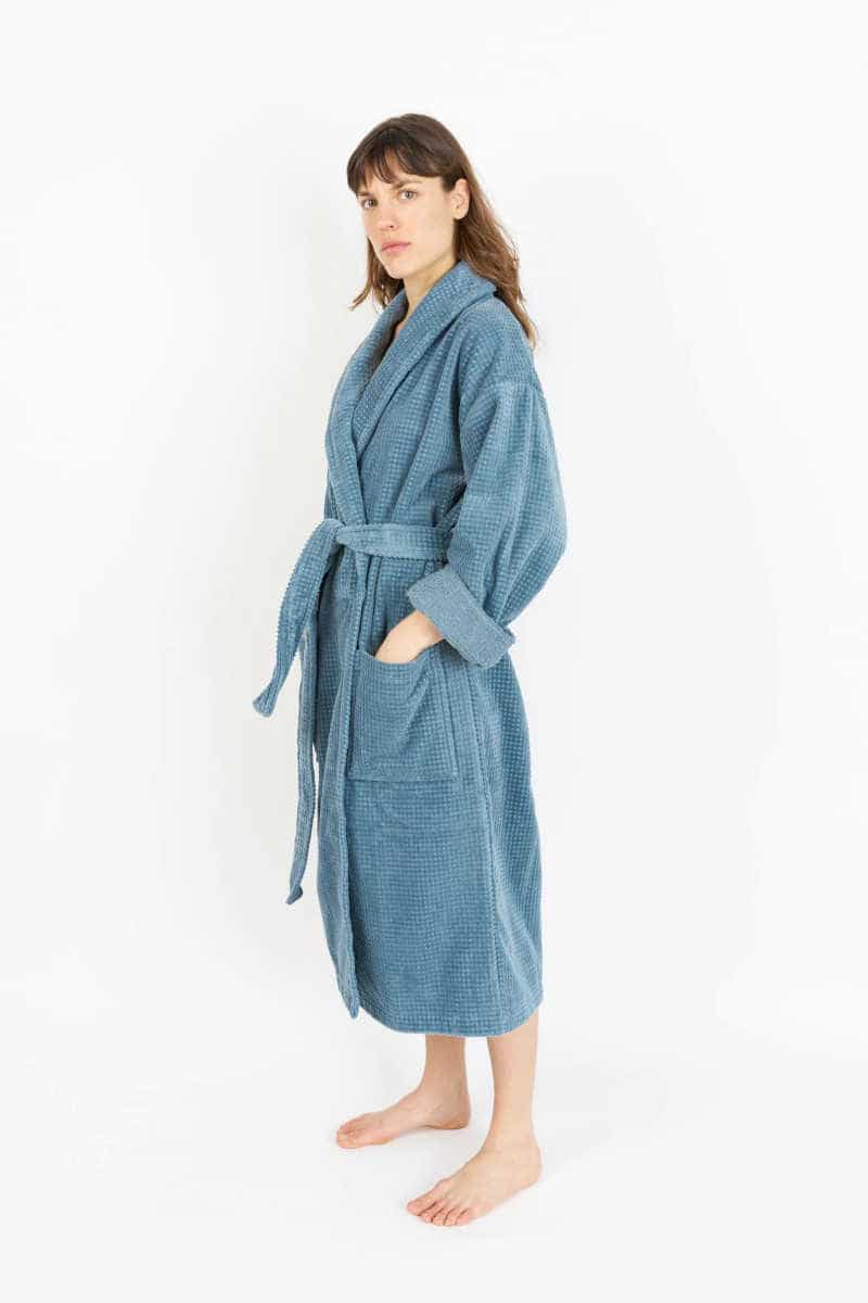 Person wearing a blue House Babylon sustainable organic cotton dressing gown.