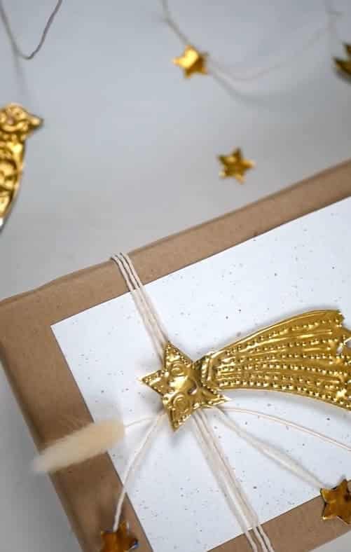 Present wrapped in brown paper, with a shooting star present topper made from embossed metal.