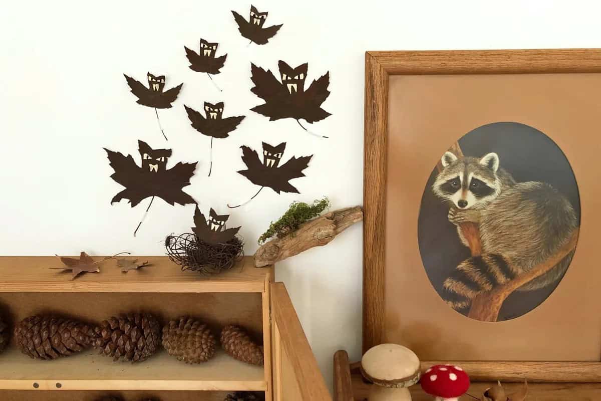 Spooky Halloween zero-waste Black bats made from leaves on a white wall.