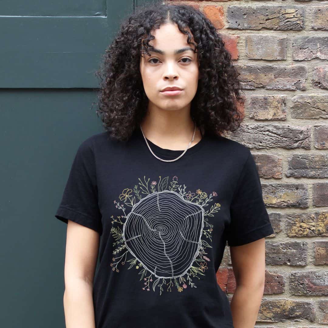 Person wearing a black t-shirt from sustainable brand Vegan Outfitters