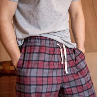 Person wearing red checked organic cotton flannel pyjama bottoms.