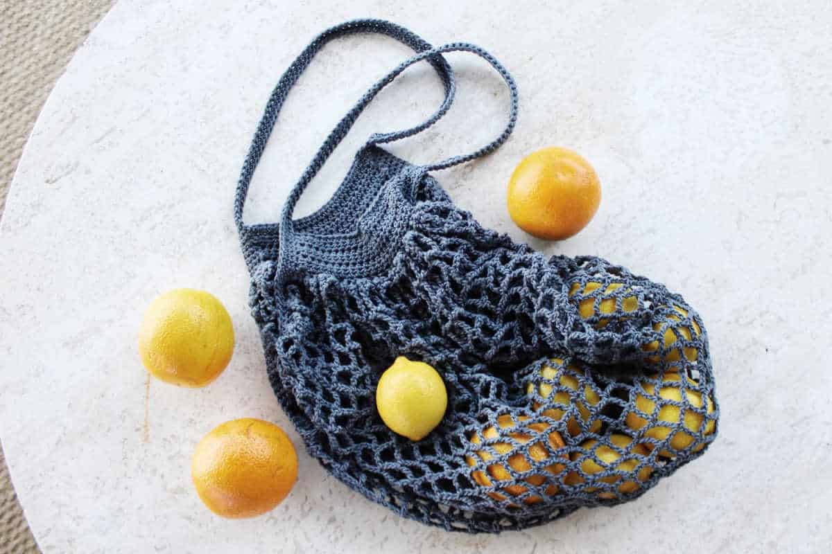 Blue French crochet market bag filled with citrus fruit.