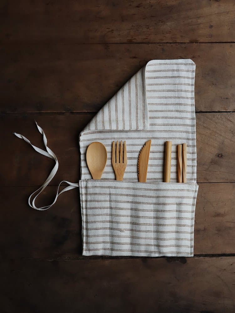 Cream and red striped cutlery wrap filled with wooden cutlery