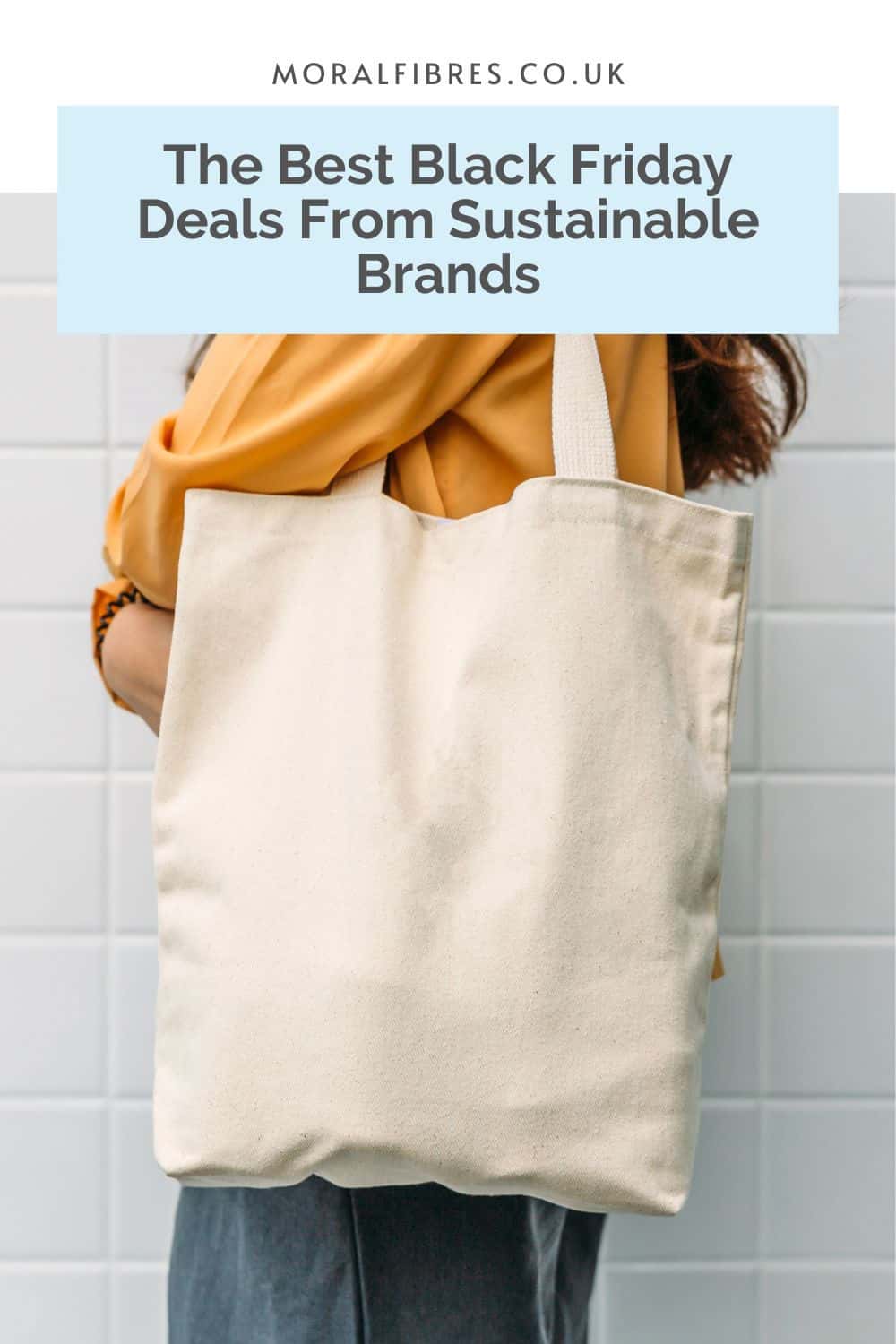 Person with dark hair and a yellow top holding a cotton tote bag, with a blue text box that reads the best Black Friday deals from sustainable UK brands.