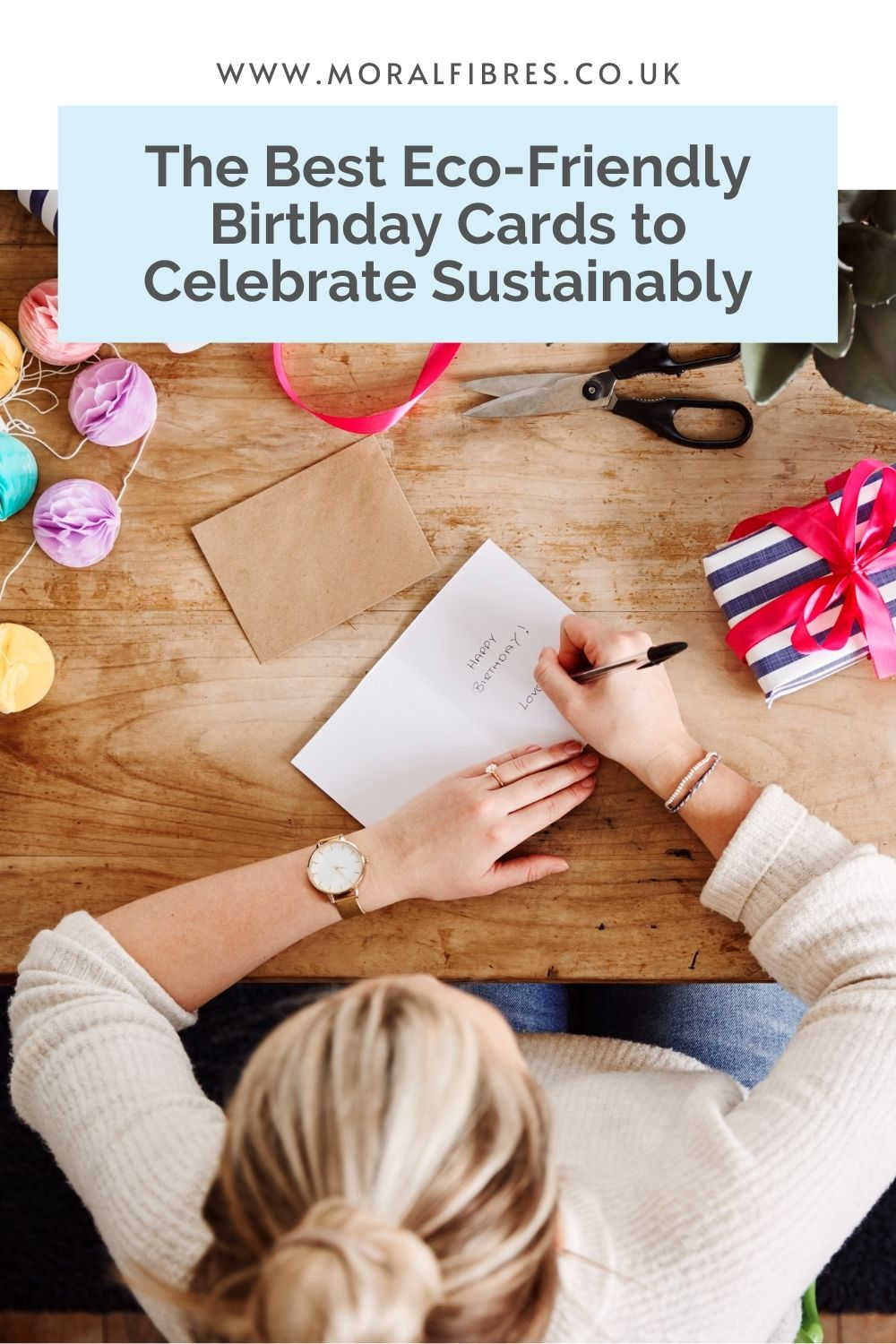 A person sitting at a table writing a greetings card with a blue text box that says the best eco-friendly birthday cards to celebrate sustainably